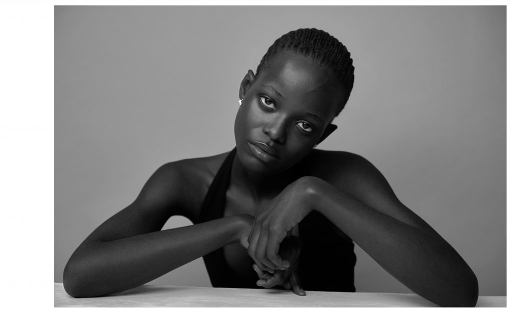 Portrait classique en noir et blanc d’une femme assise les mains jointes regard fixe – photographie par Olivier Jeanne-Rose