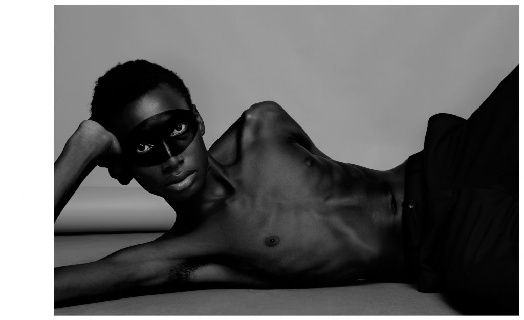 Portrait émotionnel en noir et blanc d’un homme allongé de coté avec un masque – photographie par Olivier Jeanne-Rose