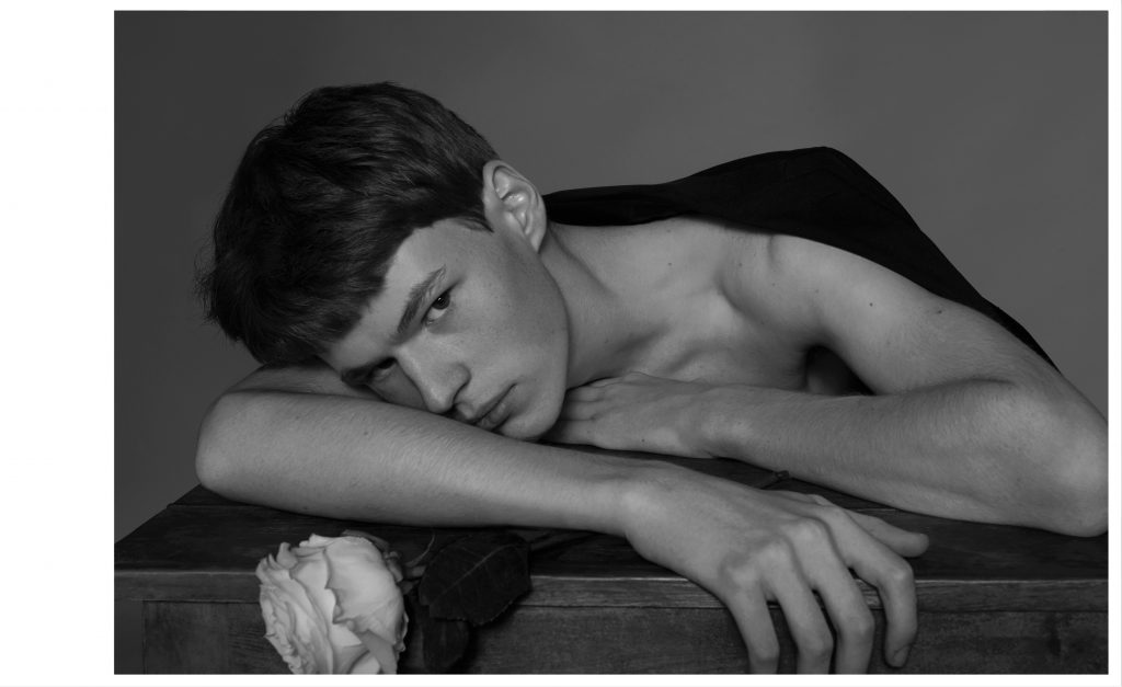 Portrait artistique en noir et blanc d’un homme avec une fleur dans une lumiere douce et intime – photographie par Olivier Jeanne-Rose